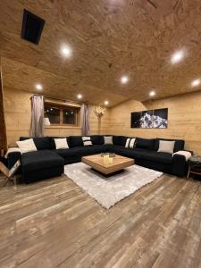 a living room with a black couch and a coffee table at Chalet Atmosphere Chamonix City Center Large T3 in Chamonix-Mont-Blanc