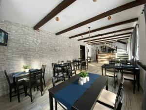 a restaurant with black tables and chairs and a brick wall at Casa Ambra in Sadova