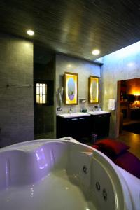 baño grande con bañera y lavamanos en Hotel Boutique Palacio de la Serna en Ballesteros de Calatrava