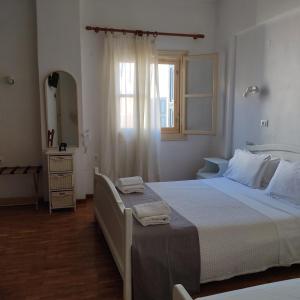 a bedroom with a large bed and a window at Anastasia Hotel in Symi