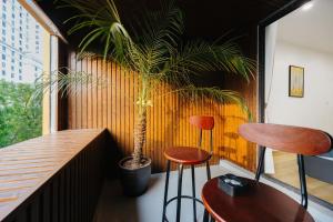 a room with a table and two stools and a plant at Muse Hanoi Serenity Suites in Hanoi