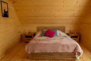 1 dormitorio con 1 cama en una habitación de madera en Chata Czarny Kot, en Janowice Wielkie