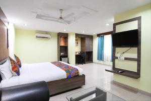 a bedroom with a bed and a flat screen tv at FabHotel Raj Residency II in Rānchī