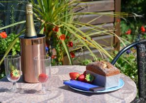a table with a bottle of champagne and a cake and strawberries at Shepherds Hut at Ridge Hall in Staithes