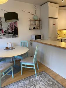 a kitchen with two tables and a counter and a refrigerator at City apartment Pikkuvuori in Turku