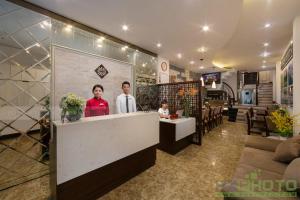 Victory Legend Hotel - In Hanoi Central في هانوي: شخصين واقفين في كونتر في مطعم