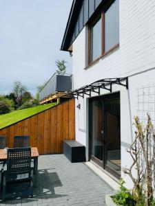 un patio avec une table et un bâtiment dans l'établissement Ferienwohnung Losenberg, à Olsberg