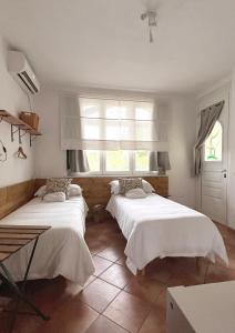 2 camas en una habitación con ventana en Il Sassoscritto Bed and Breakfast, en Montecalvo Versiggia