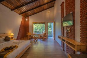 a bedroom with a bed in a room with a brick wall at The Destin Ekaant By 3Tree Group in Belparāo