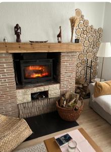 uma sala de estar com lareira de tijolos e lareira em Maison Normandie 