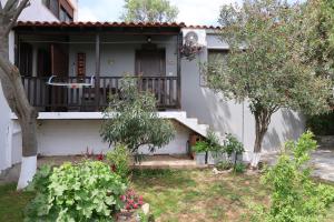 a house with a balcony and some trees and flowers at ANASTASIA in Mákri