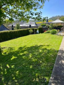 podwórko z dużym trawnikiem z domem w tle w obiekcie Maison Normandie 