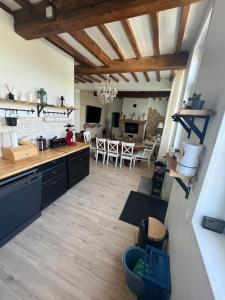 kuchnia i salon z drewnianymi podłogami i sufitami w obiekcie Maison Normandie 