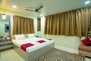a bedroom with a bed and a ceiling fan at Hotel Gokul Palace in Hāora