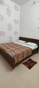 Bett in einem Zimmer mit einem Teppich auf dem Boden in der Unterkunft Maa kaushalya Guest House in Ayodhya in Ayodhya