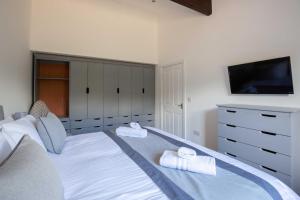 a bedroom with a white bed with towels on it at York Cottage in Cirencester