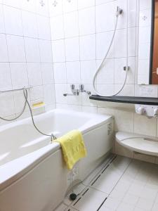 ein weißes Bad mit einer Badewanne und einem WC in der Unterkunft Hashima - Hotel - Vacation STAY 52815v in Hashima
