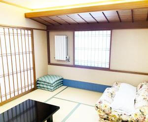 Zimmer mit Sofa, Tisch und Fenstern in der Unterkunft Hashima - Hotel - Vacation STAY 52815v in Hashima