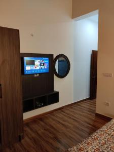uma sala de estar com uma televisão de ecrã plano na parede em Oakakhi Stays, private room em Ranikhet