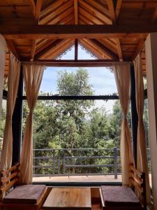 uma grande janela num quarto com uma mesa de madeira em Oakakhi Stays, private room em Ranikhet
