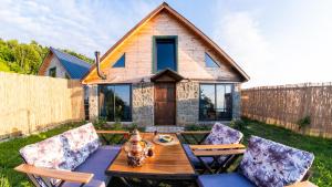 a backyard with a wooden table and chairs and a house at Şahmaran Bungalov in Ardeşen