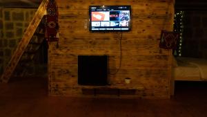 a television in a room with a log wall at Şahmaran Bungalov in Ardeşen