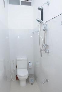 een witte badkamer met een toilet en een douche bij The Colombo Village in Colombo