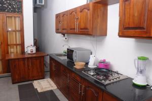 uma cozinha com armários de madeira e um forno com placa de fogão em The Colombo Village em Colombo
