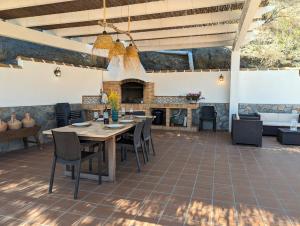 een patio met een tafel en stoelen en een open haard bij Cortijo Claudia in Taberno