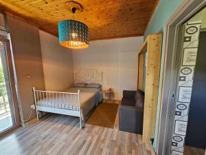 1 dormitorio con cama y lámpara de araña en Μέντα 1, en Kalamata