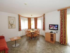 ein Wohnzimmer mit einem Tisch, Stühlen und einem TV in der Unterkunft Attractive holiday home in Kaltenbach on the ski slope in Stumm