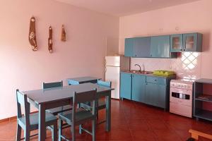 a kitchen with blue cabinets and a table and chairs at Appartamento Serra. Stella Maris Exclusive in Calheta Do Maio