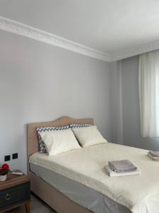 a white bedroom with a bed and a window at Akçaabat'ta Müstakil Ev in Akcaabat