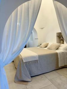a bedroom with two beds with white curtains at Lamacesare in Cisternino