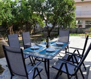 a blue table with chairs and a bottle of wine at Betty's Garden House in Nea Anchialos