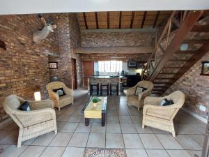 a large living room with chairs and a table at Khumbula iAfrica 2 in Marloth Park