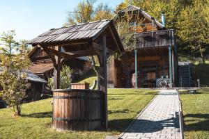a wooden cabin with a trash can in front of it at KAJZA KOLOVRAT in Mozirje