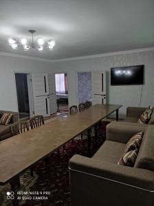 a living room with a large wooden table and chairs at Your House in Karakol