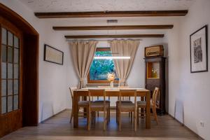 Un comedor con mesa y sillas y una ventana. en EPA Apartment - España style, en Rust