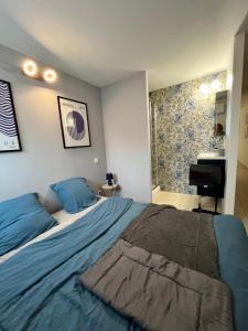 a bedroom with a bed with blue sheets and a piano at La provence avec piscine privative en campagne in Pernes-les-Fontaines +39 photos