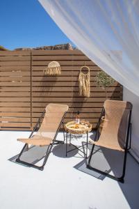two chairs and a table on a patio at Bliss Luxury Suites in Líndos