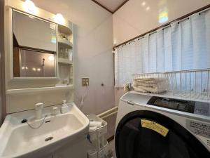 ein Badezimmer mit einer Waschmaschine und einem Waschbecken in der Unterkunft 百代家 飛騨高山 若達町 in Takayama