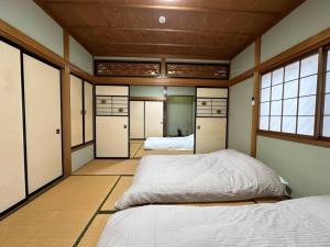 Zimmer mit 2 Betten in einem Zimmer mit Fenstern in der Unterkunft 百代家 飛騨高山 若達町 in Takayama