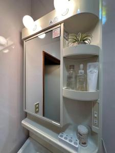 einen Medizinschrank mit einem Spiegel im Bad in der Unterkunft 百代家 飛騨高山 若達町 in Takayama