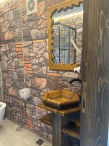 a stone bathroom with a wooden sink and a mirror at FİÇİTA BUNGALOv in Dikkaya