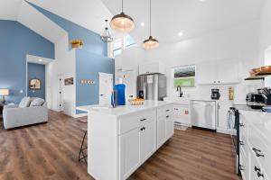 a kitchen with white cabinets and a blue wall at Majestic on TableRock home in Branson