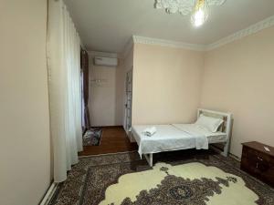 a small bedroom with a bed and a rug at Boulevard in Bukhara