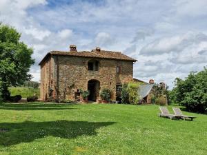 シナルンガにあるPodere Pievina Delle Corti - Dimora di Campagnaの畑のベンチ付きの古い石造りの建物