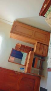 a wooden cabinet with a mirror in a room at BG archange in Cotonou