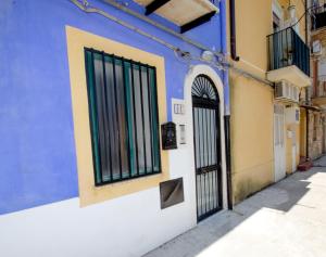 um edifício azul e amarelo com um portão em Antico Rione em Caltanissetta